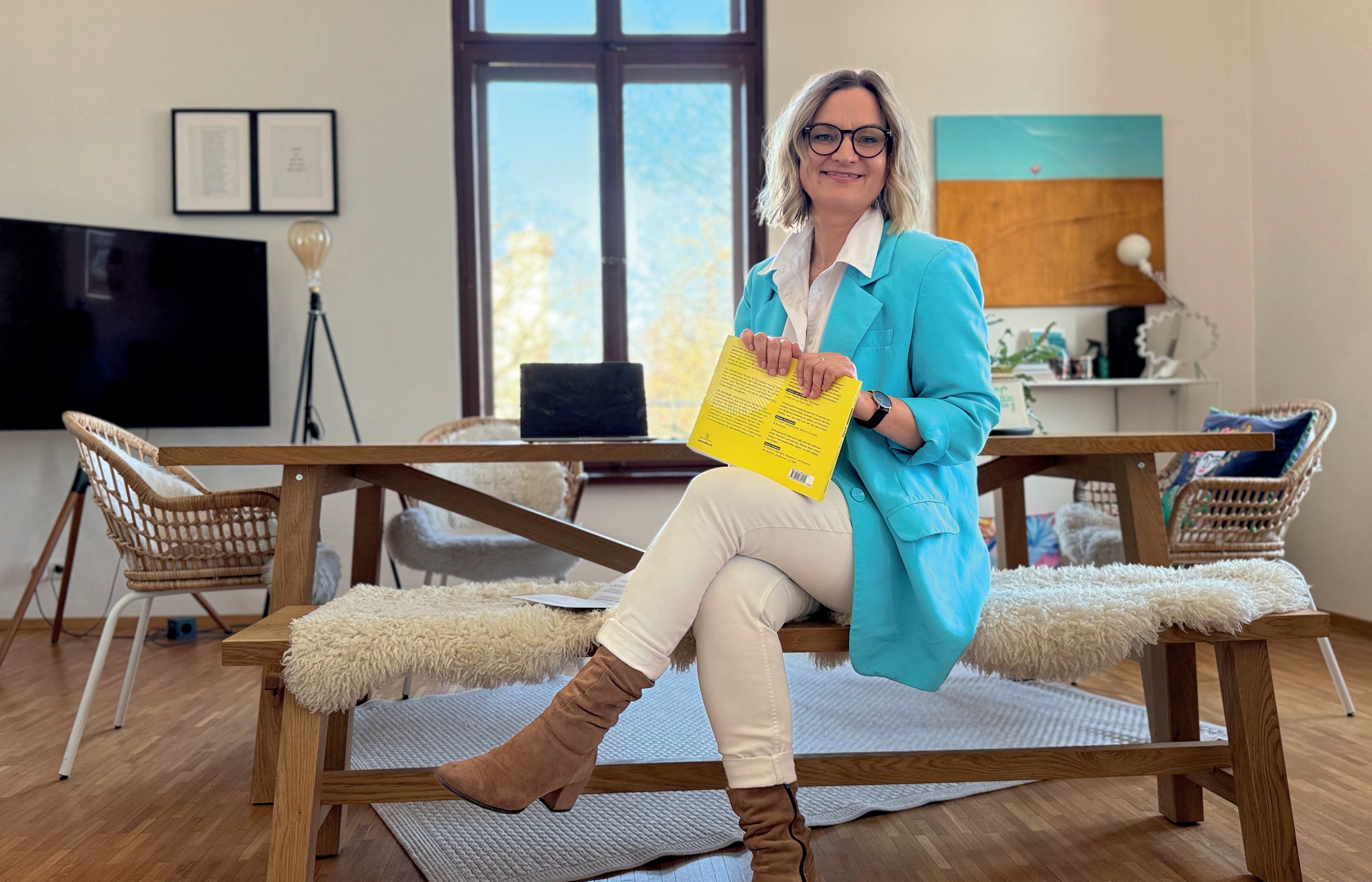 Anja Wernecke auf einer Bank mit gelbem Buch